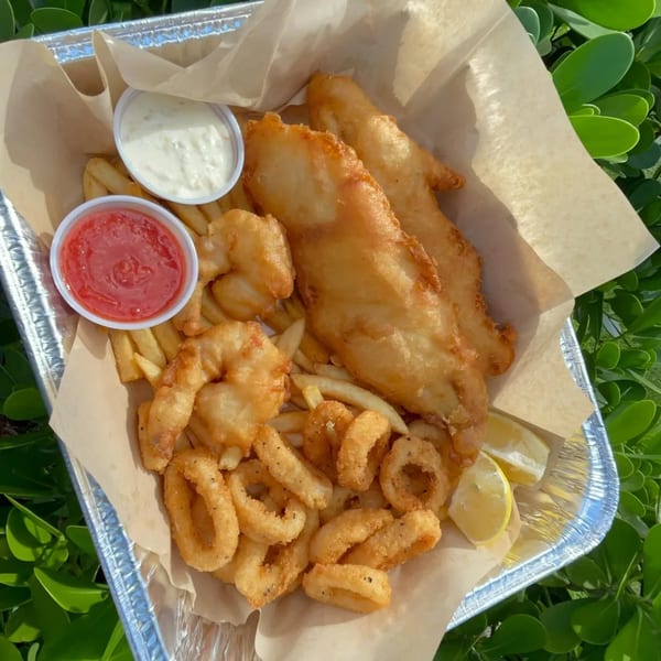 Kiwi Style Fish and Chips platter with fried fish, shrimp, calamari, fries, and sauces.